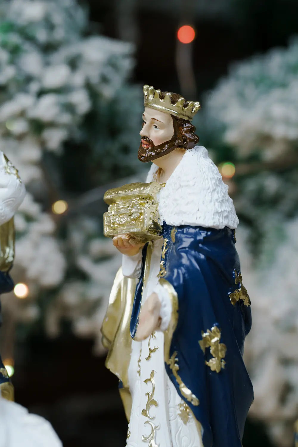 figurine of a crowned king in a gold crown, holding a gold box.