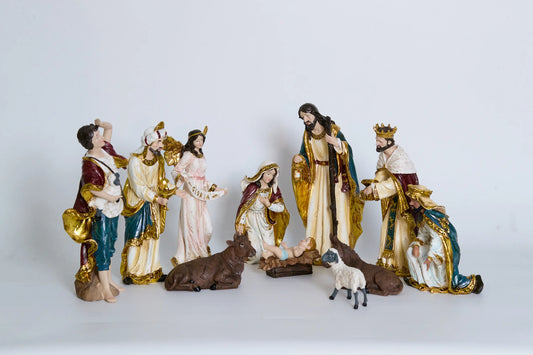 11 nativity figurines on white background including Holy Family, Magi, shepherd, Gloria angel, and stable animals