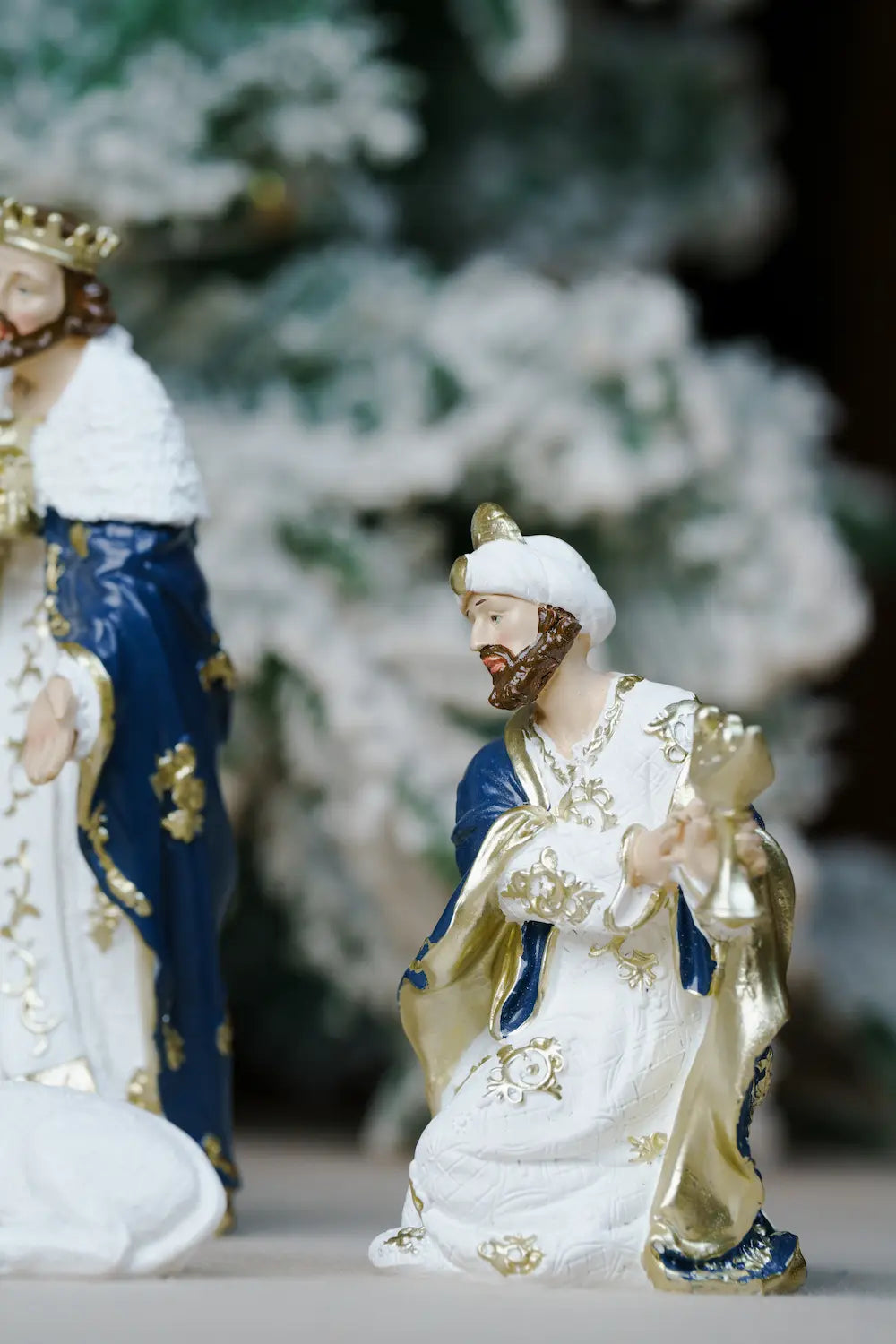 white and gold nativity figurine of a kneeling wise man with golden vessel 