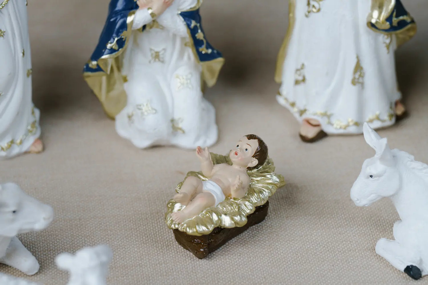 A nativity scene figurine of baby Jesus in a gold manger