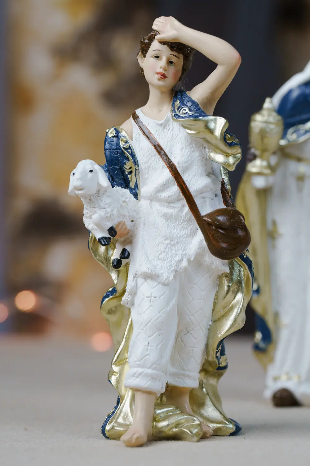 shepherd cradling lamb blue white gold nativity figurine