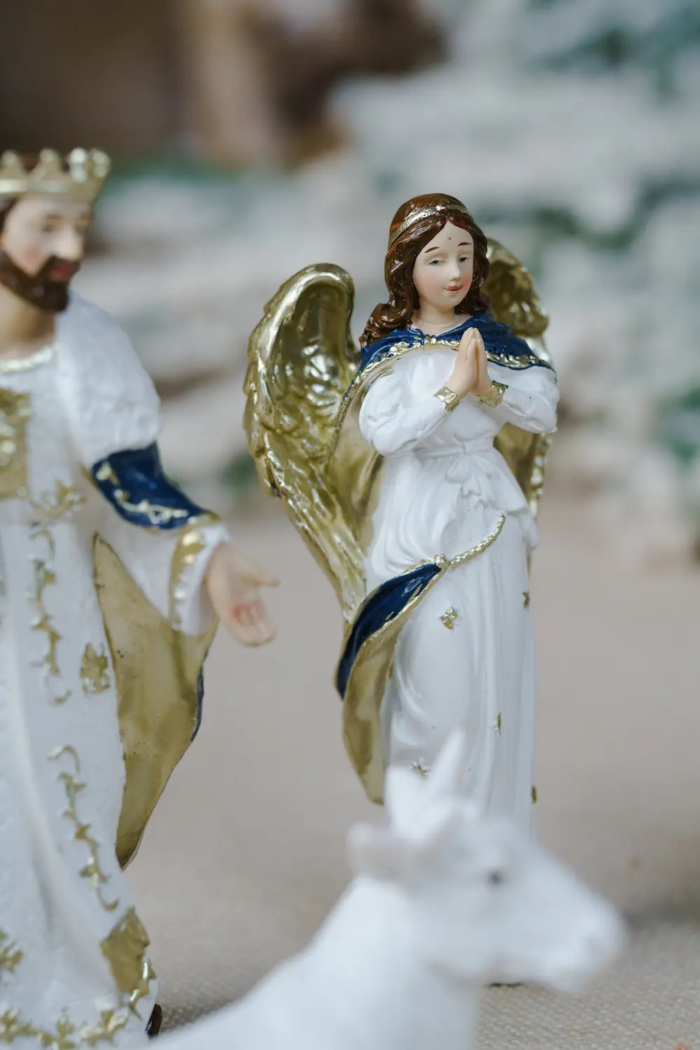 white angel figurine with gold wings and blue trim.