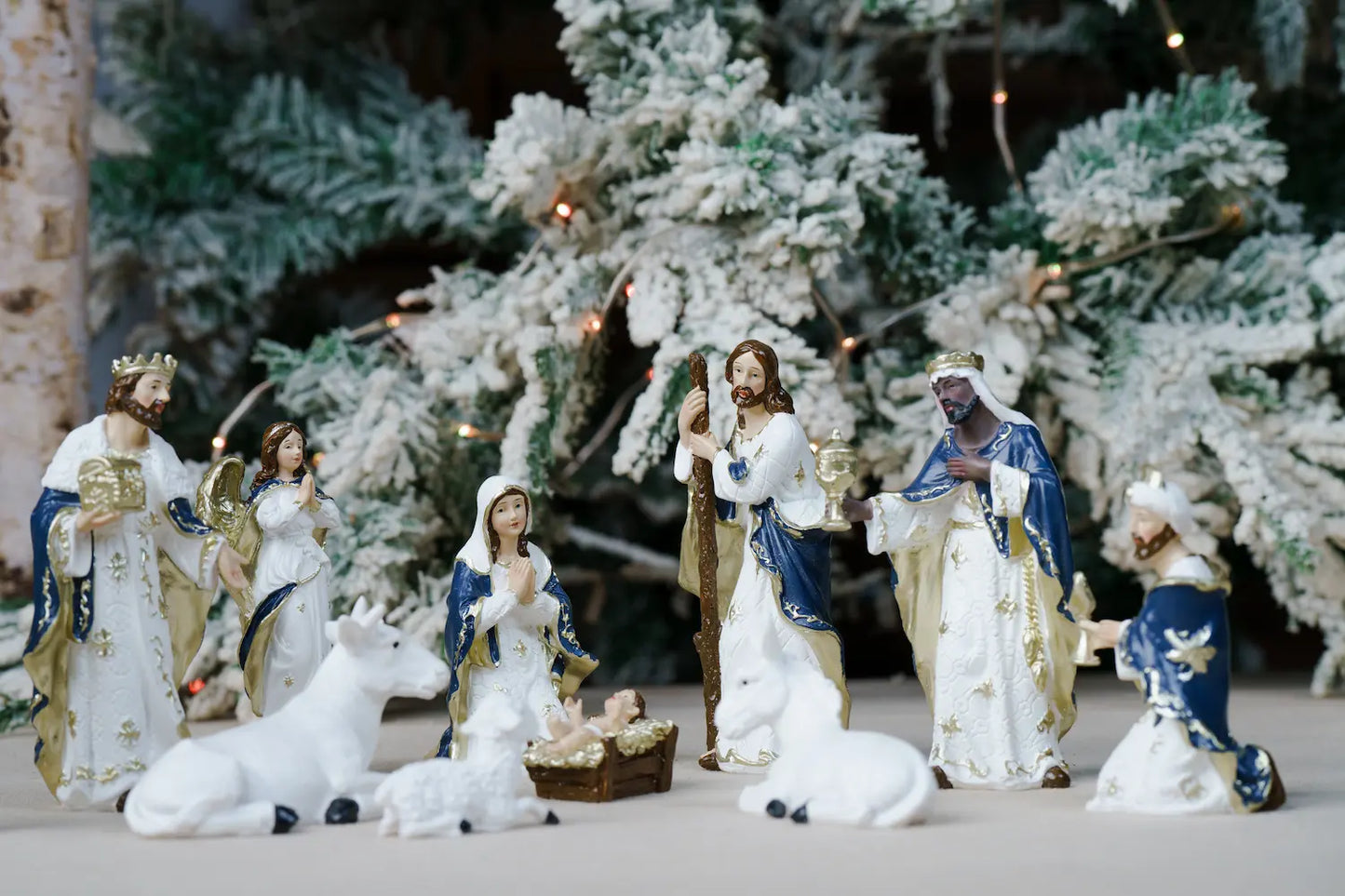 A Christmas nativity scene figurine set featuring Mary, Joseph, baby Jesus in a manger, wise men, angels, and animals.