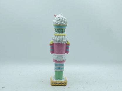 Back view of the candyland nutcracker figurine showing striped uniform and frosting details