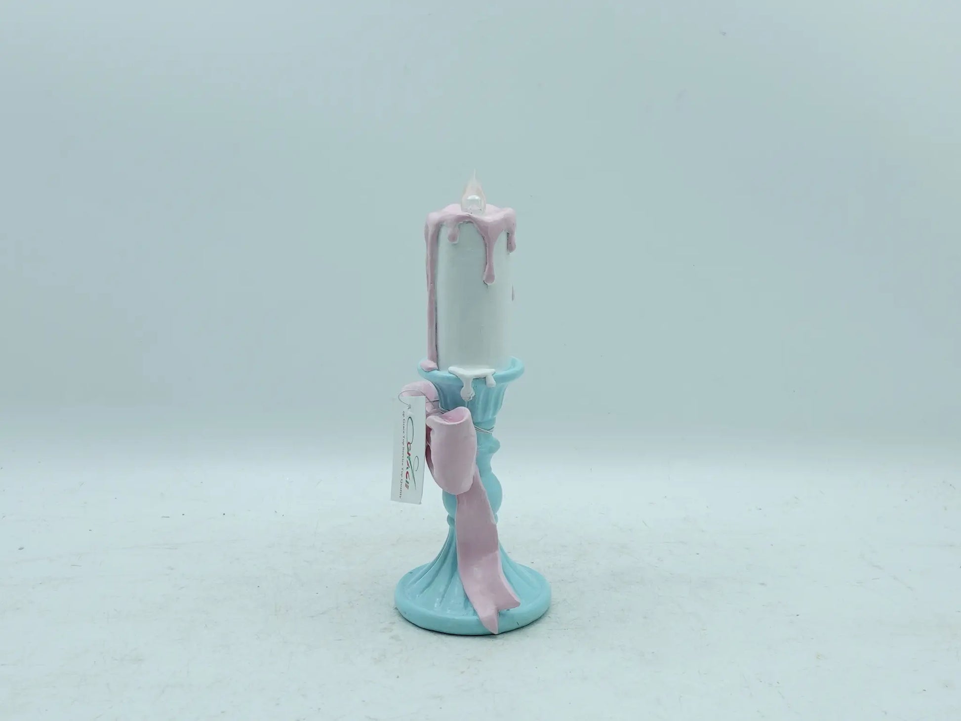 resin candle holder figurine displaying the flowing pink ribbon bow detail, side view