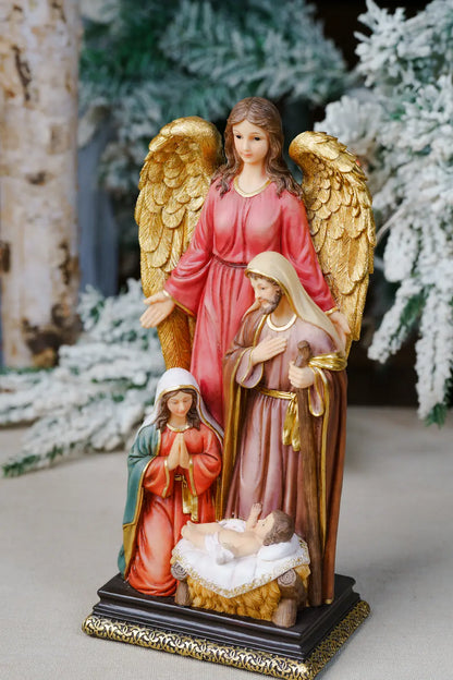 A painted nativity figurine featuring an angel with large gold wings, Mary, Joseph, and baby Jesus in a stable