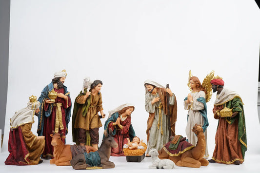 Complete 12-piece colorful nativity scene on white studio background showing full crèche arrangement