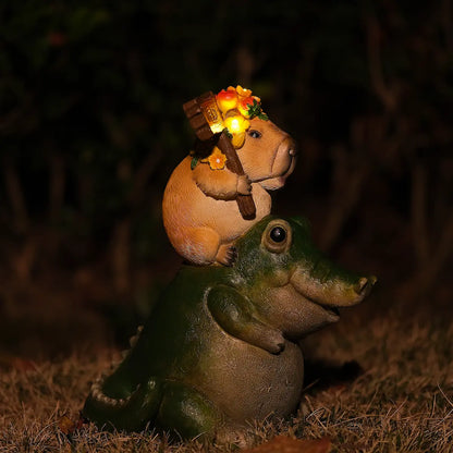 whimsical glowing capybara alligator garden statue with illuminated crown on grassy lawn