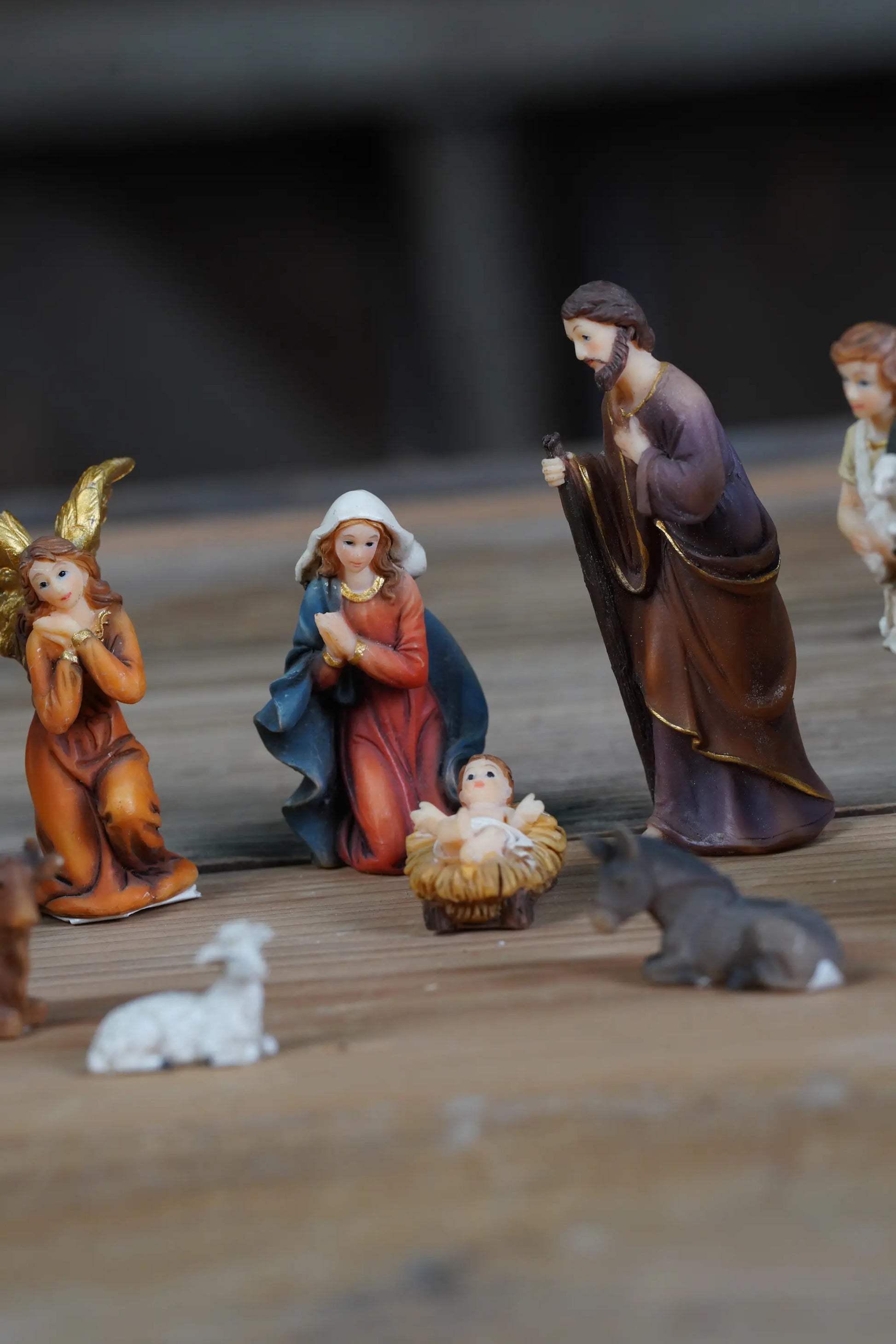 Close-up of Holy Family mini nativity figures, Baby Jesus in manger centerpiece.