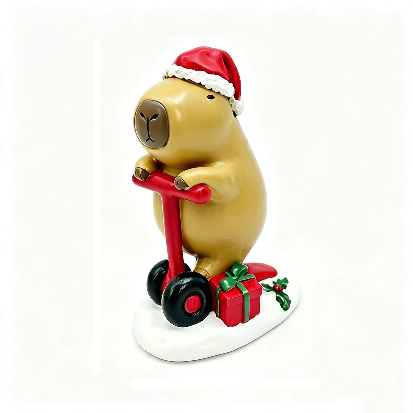 A Christmas capybara figurine wearing a red Santa hat and riding a red scooter, with a red gift box and green holly on a white base