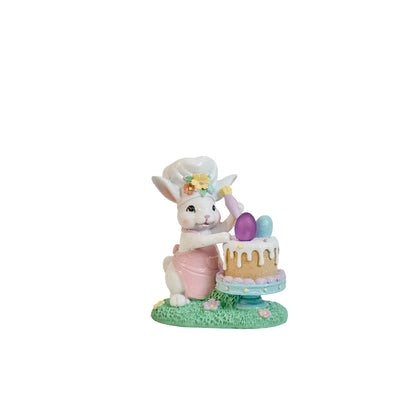 Hand-painted Easter bunny chef figurine decorating a cake with pastel eggs