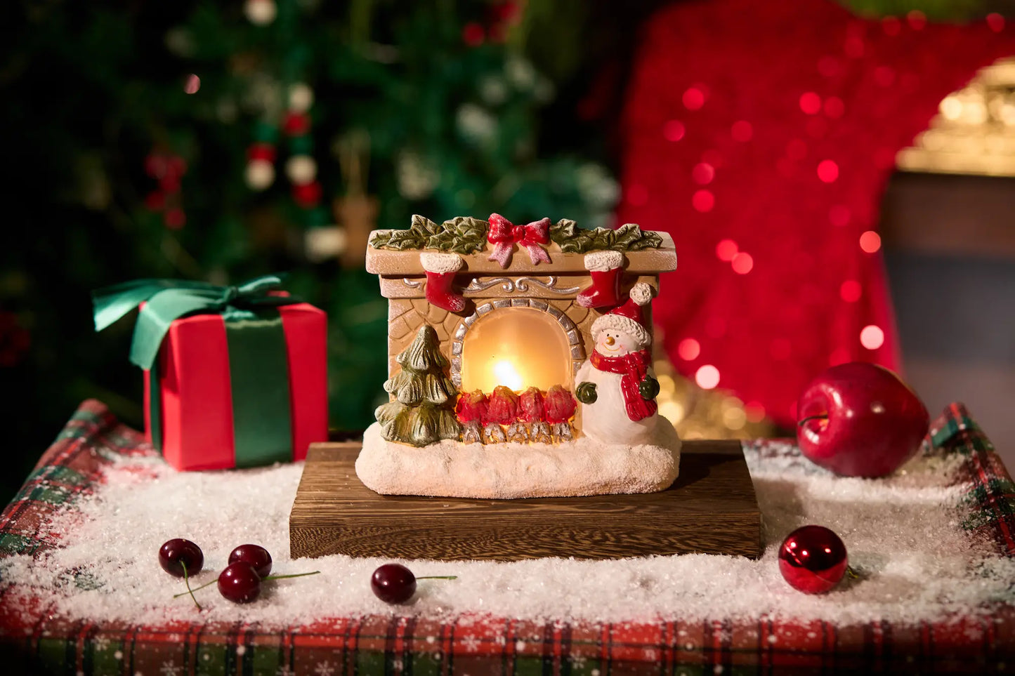 Lighted snowman fireplace figurine with LED glow on festive Christmas table setting
