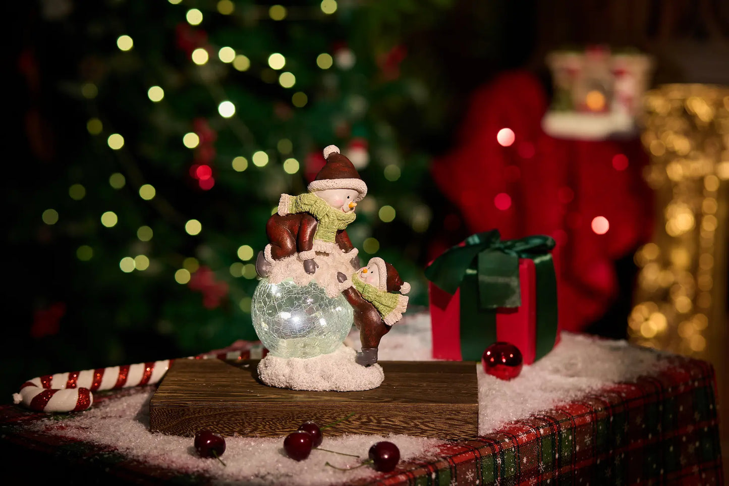 Zayton lighted snowman figurine with crackle-glass glowing ball on wood surface— warm LED Christmas decoration