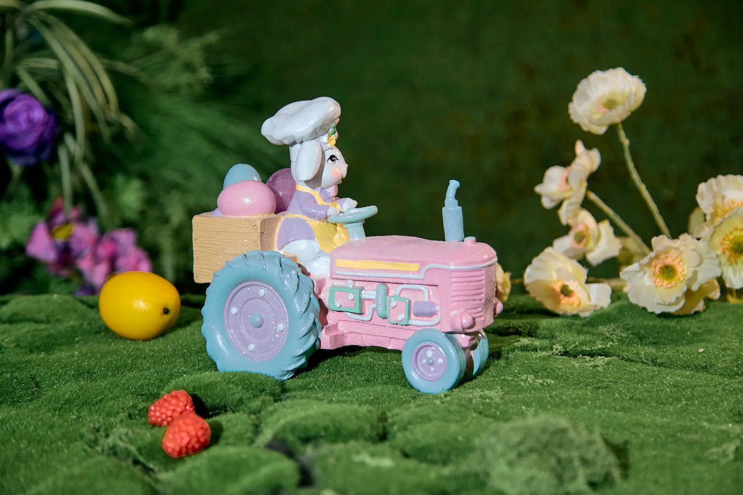 Easter bunny tractor figurine showing wooden egg crate and mint-green tractor detail — cottagecore spring resin décor in garden setting
