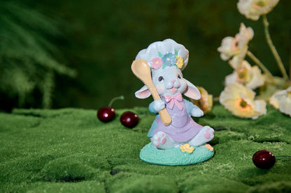 Seated Easter bunny chef figurine on moss surface with cherries and spring flowers — glitter resin cottagecore spring decoration