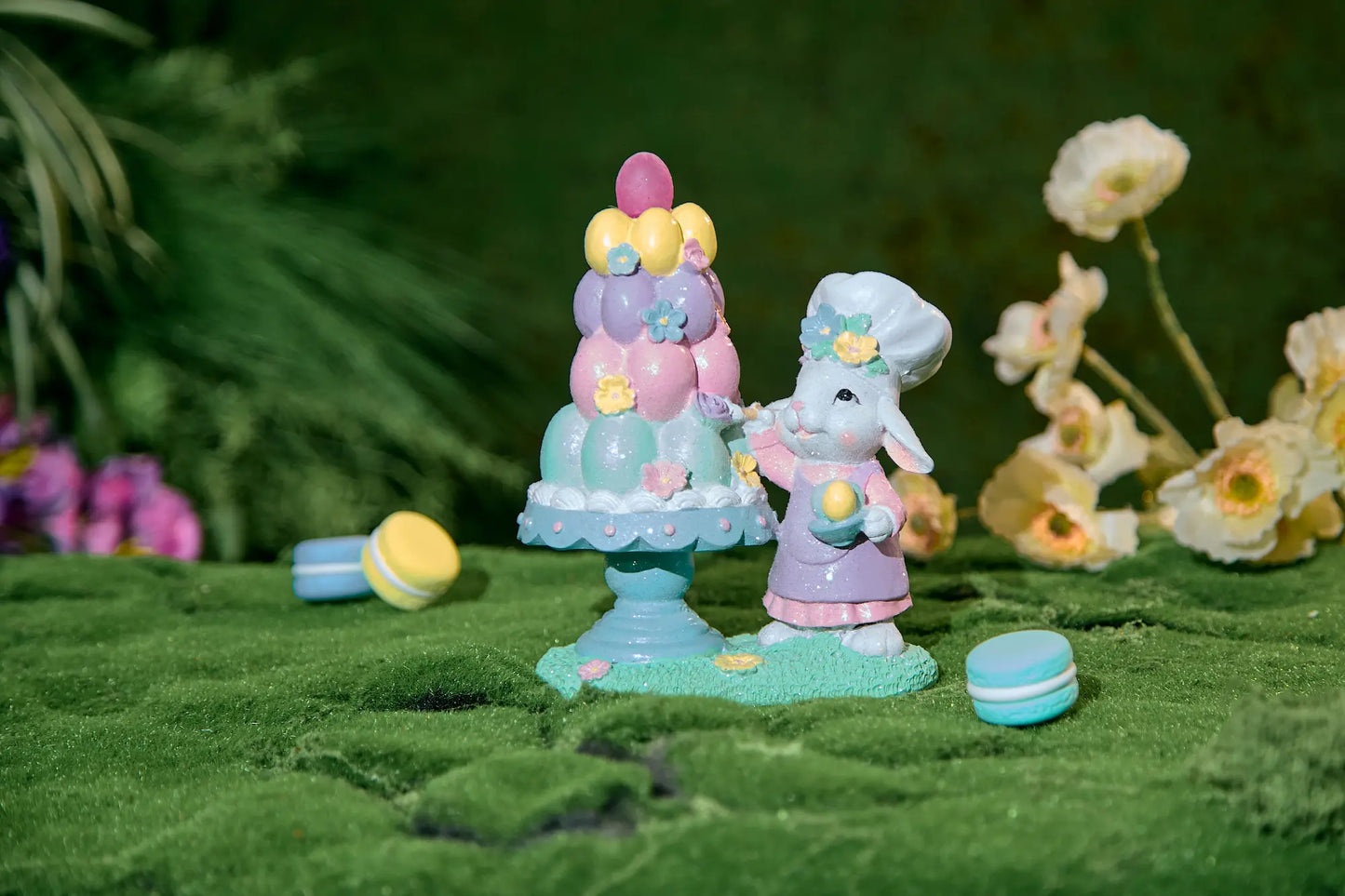 Easter bunny chef figurine beside tiered pastel egg tower on scallop cake stand — spring cottagecore resin decoration