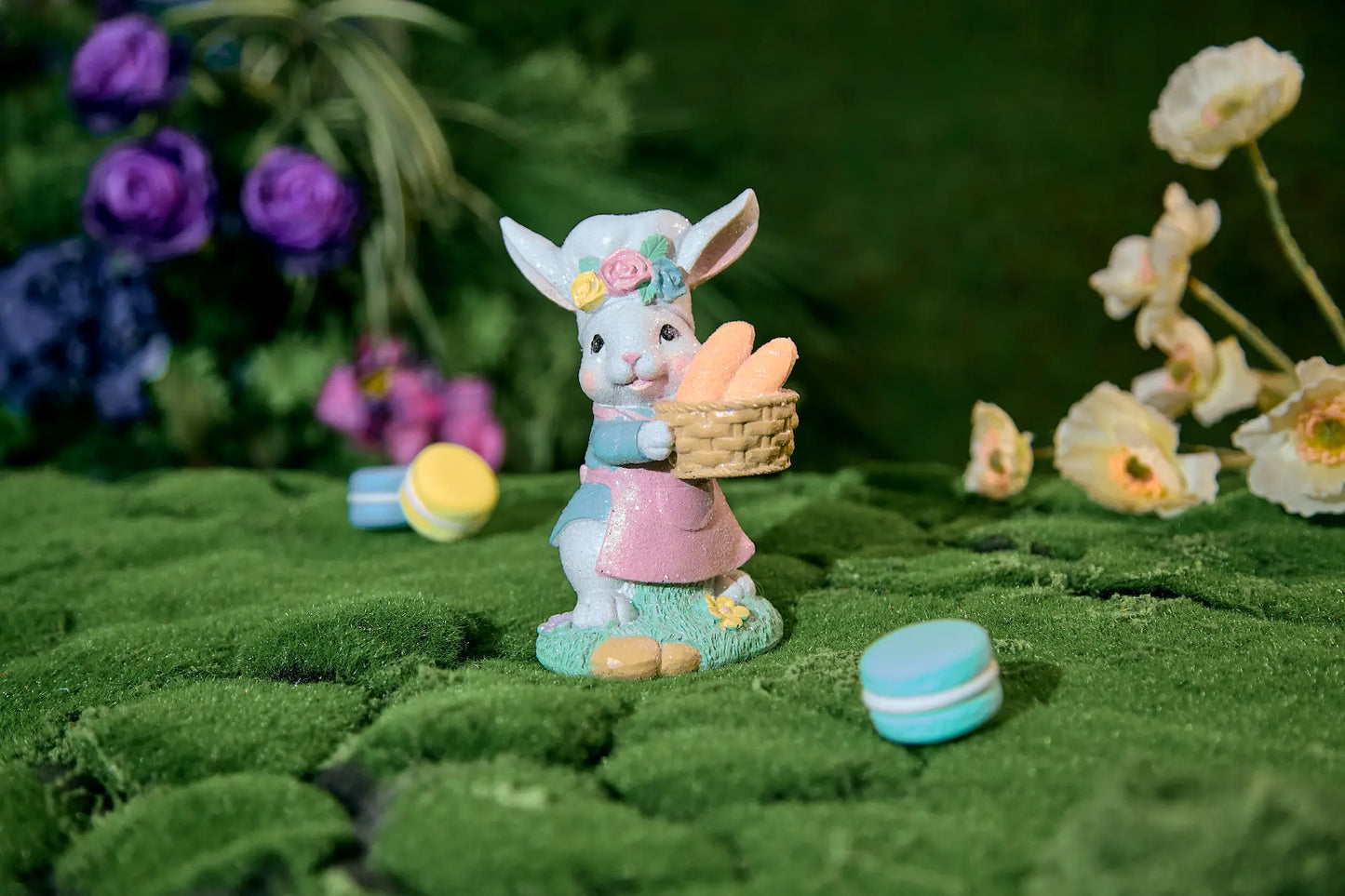 Hand-painted resin bunny baker figurine in garden setting with macarons