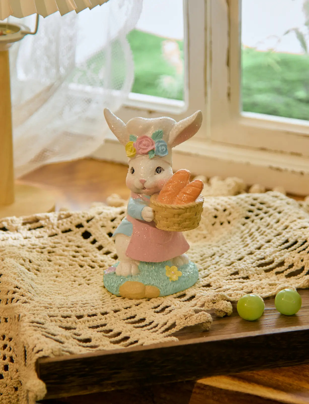Easter bunny baker decoration on lace doily by window with lamp