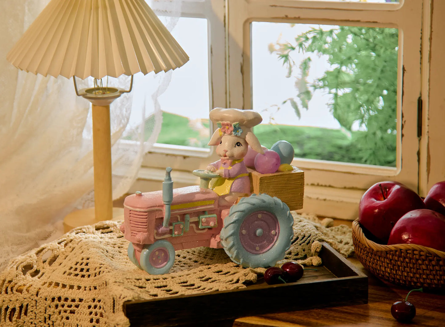 Easter bunny tractor figurine on crochet doily beside window