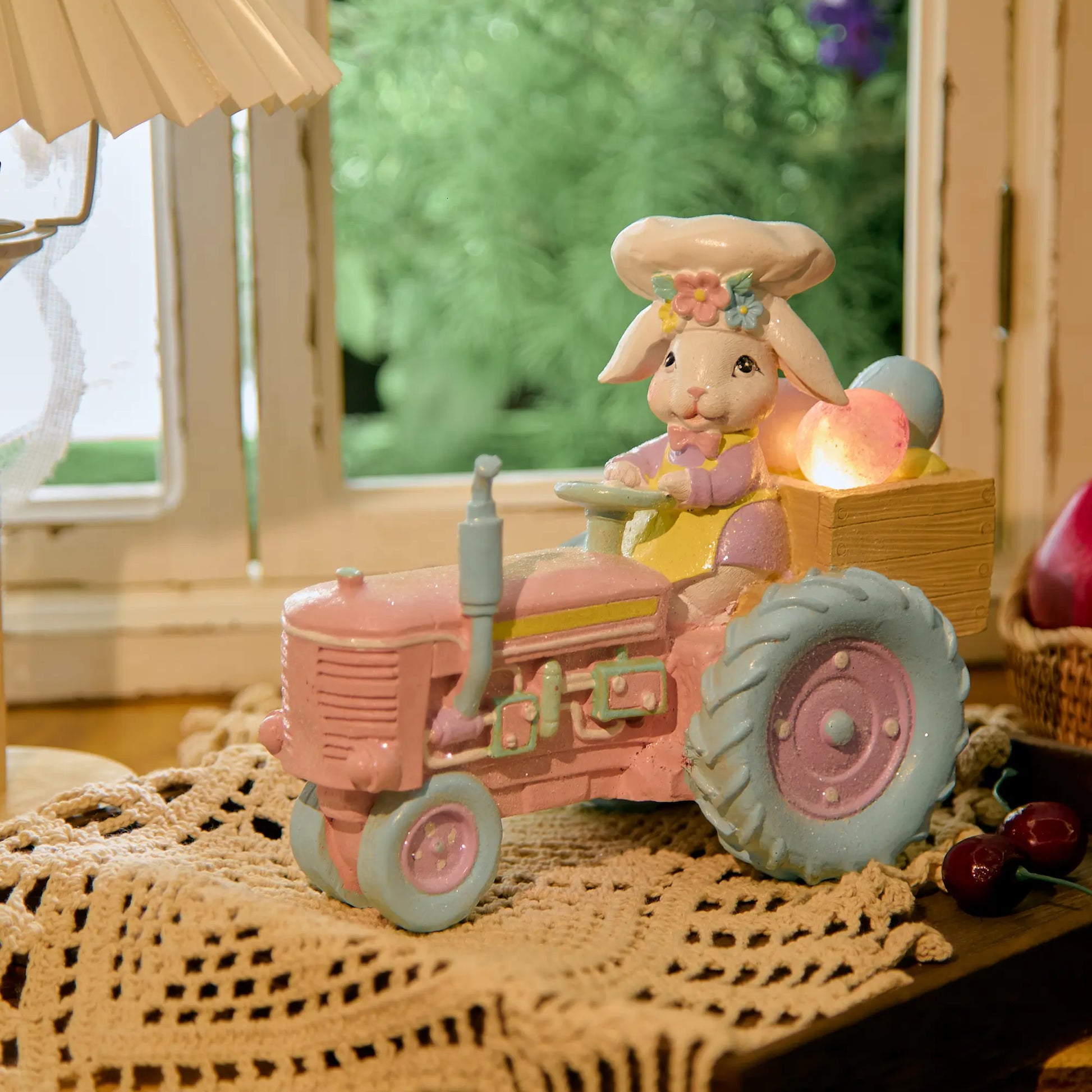 Lighted Easter bunny tractor figurine with glowing egg cargo on lace doily
