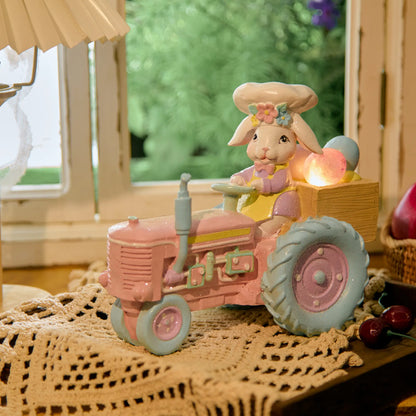Lighted Easter bunny tractor figurine with glowing egg cargo on lace doily
