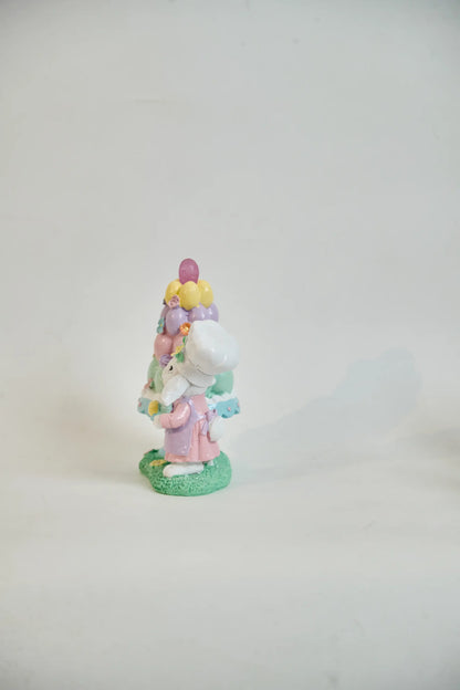 Side view of Easter bunny baker figurine showing chef toque, lavender apron, and egg bowl detail — hand-painted glitter resin spring decoration