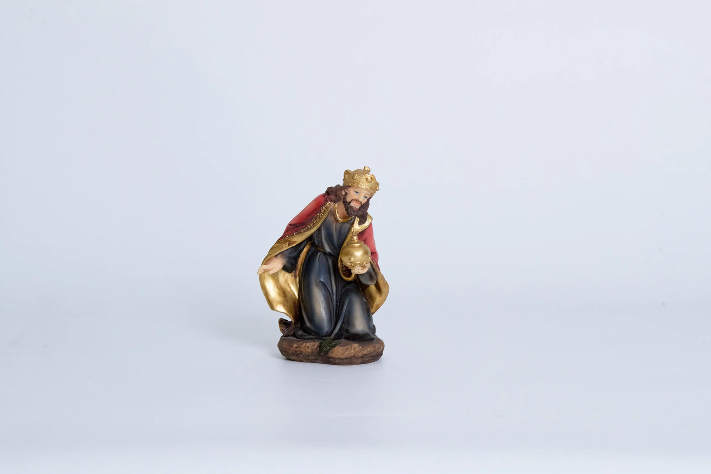 Kneeling Wise Man nativity figurine — Three Kings figure in navy and crimson robes with gold crown presenting golden orb offering, hand-painted resin
