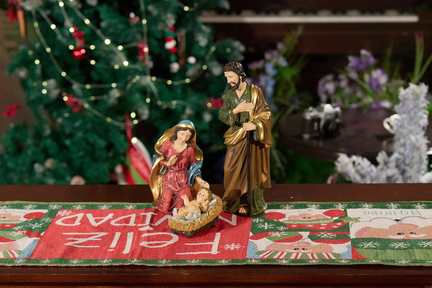 Holy Family nativity scene close-up on holiday table runner, Mary Joseph and Baby Jesus.
