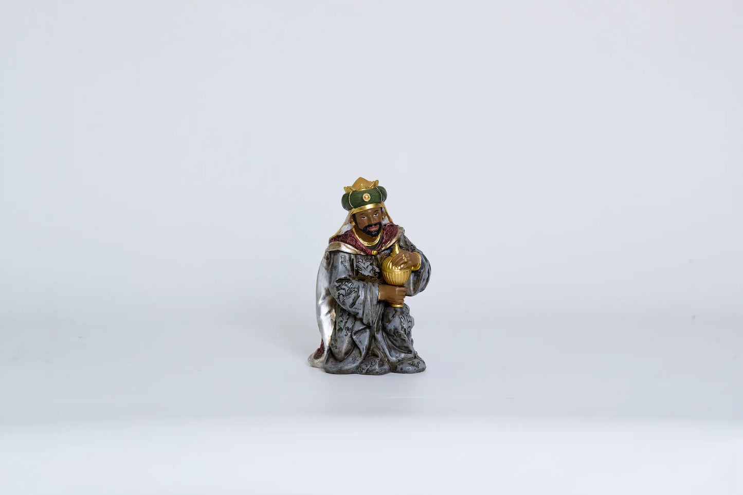 Kneeling Wise Man figurine close-up, Magi figure for Christmas nativity decor.