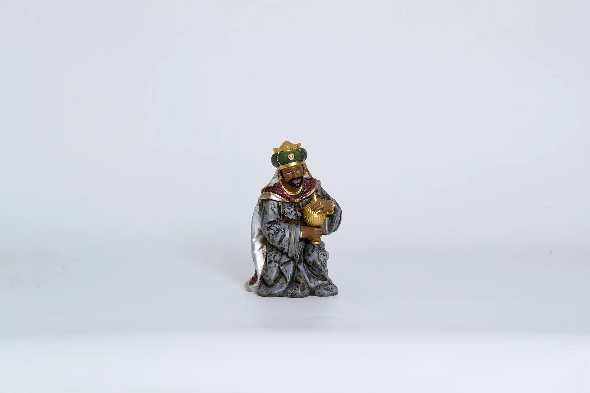 Kneeling Wise Man figurine close-up, Magi figure for Christmas nativity decor.