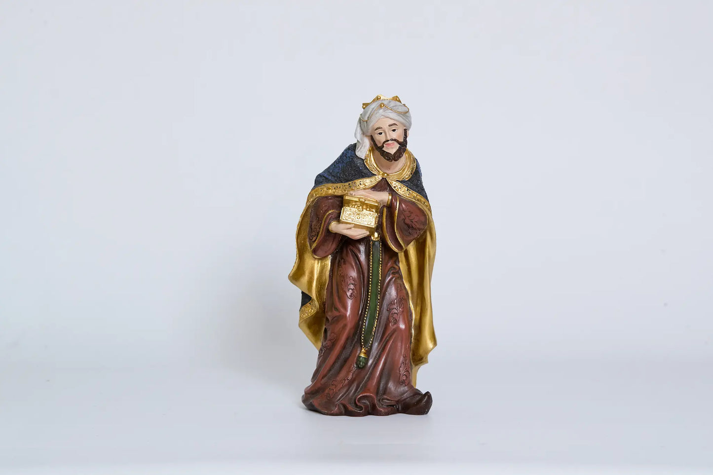 Standing Wise Man holding treasure chest, Magi nativity figurine close-up.