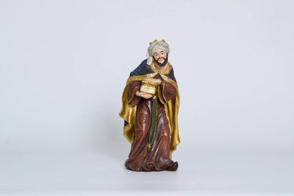 Standing Wise Man holding treasure chest, Magi nativity figurine close-up.