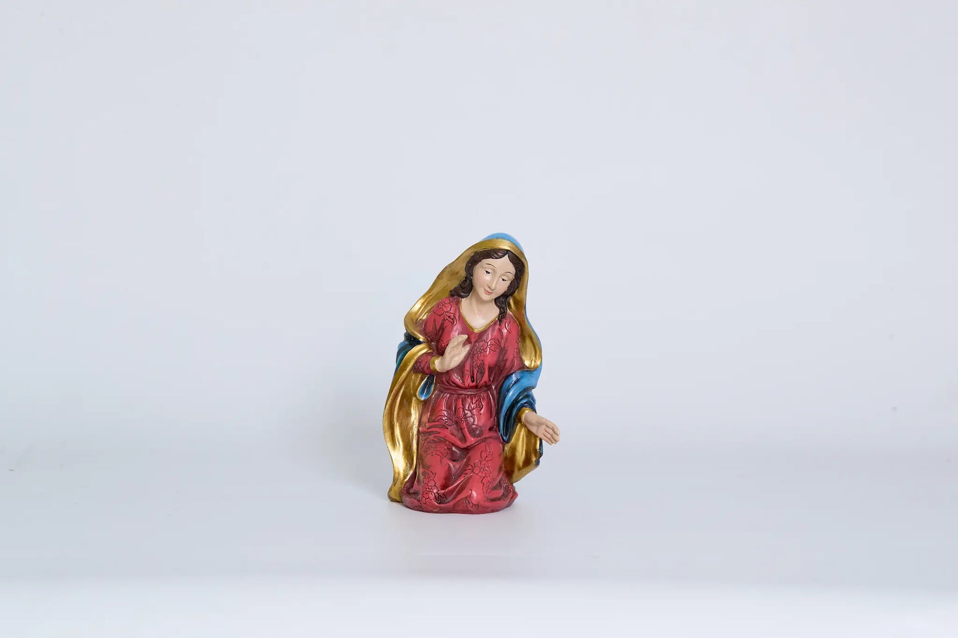 Kneeling Mary figurine close-up, nativity Holy Family figure for Christmas decor.