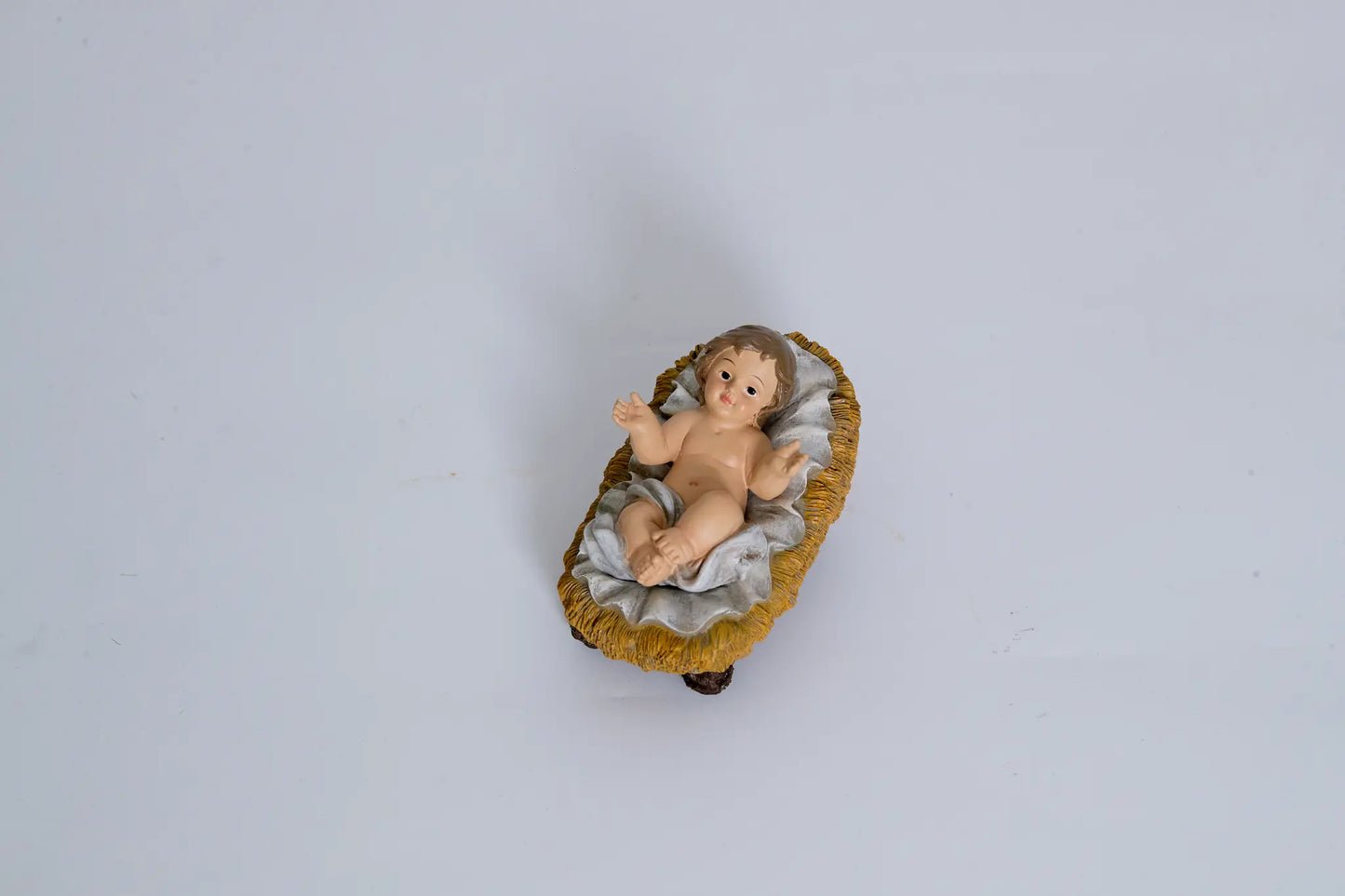 Baby Jesus in manger figurine close-up, nativity infant Jesus figure.