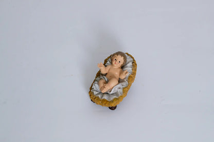 Baby Jesus in manger figurine close-up, nativity infant Jesus figure.