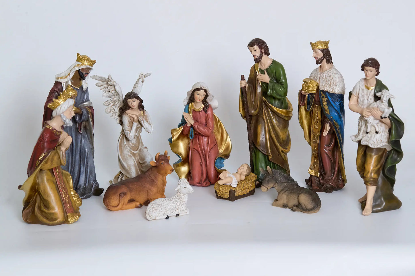 Complete 11-piece nativity scene set on white background — hand-painted resin Holy Family, Three Kings, angel, shepherd, and animals
