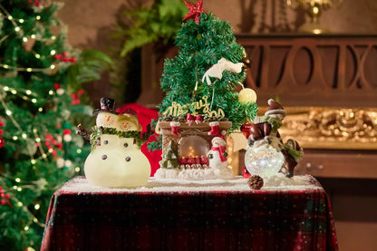 Zayton snowman couple figurine displayed with crackle-glass snowman and lighted fireplace figurine — Christmas snowman decoration collection on plaid surface