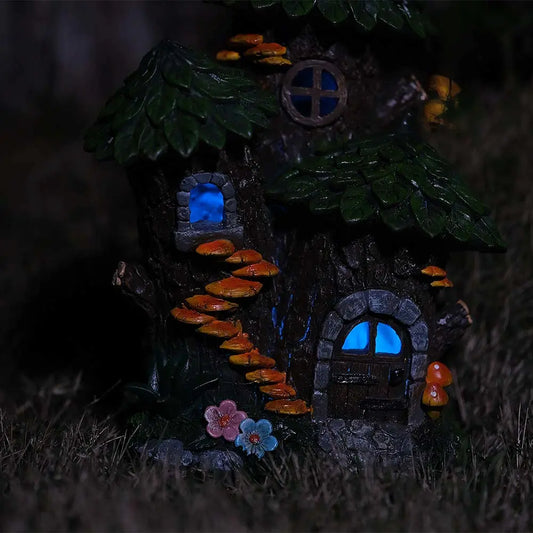 Solar fairy house glowing blue light at night in outdoor garden
