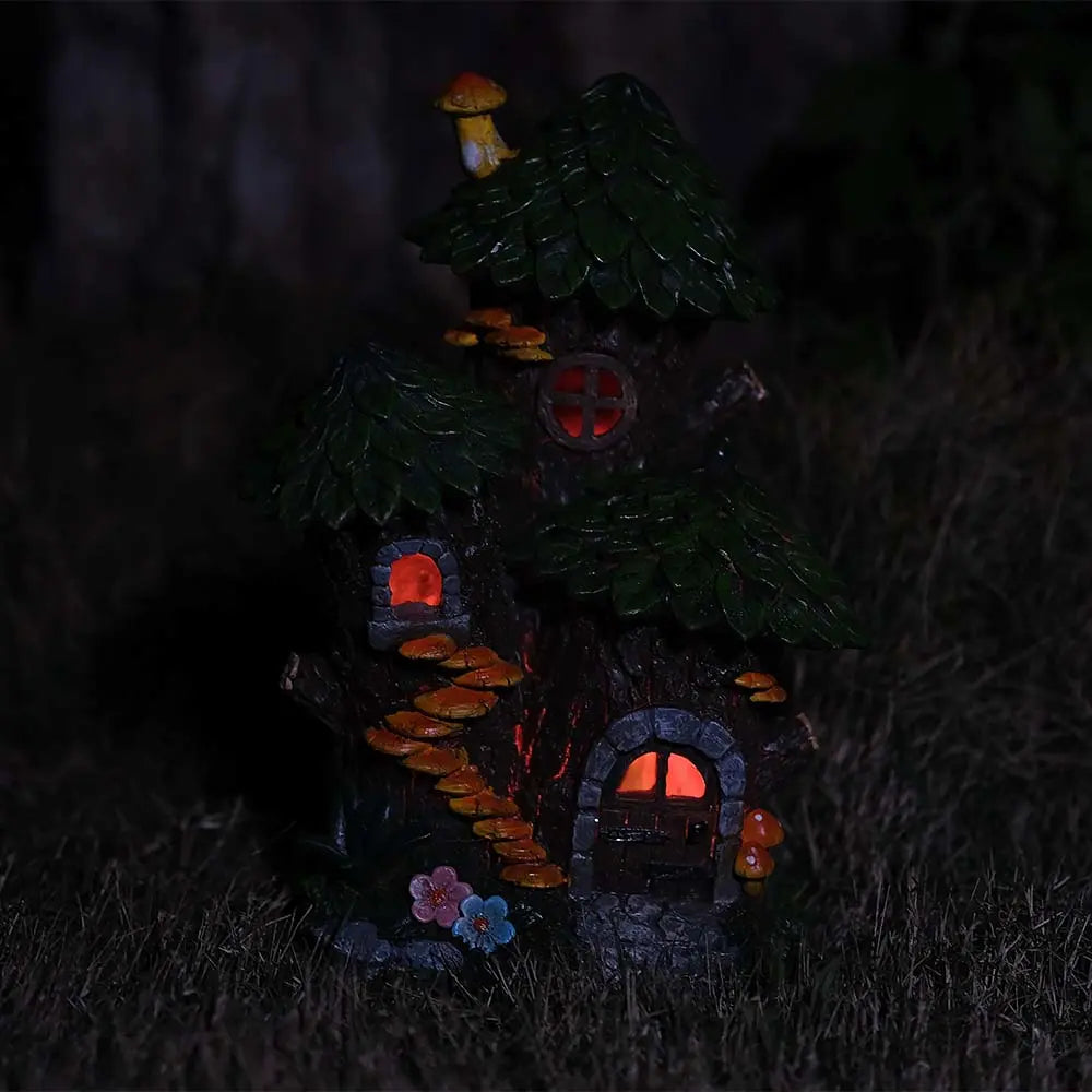 Solar fairy house glowing blue light at night in outdoor garden