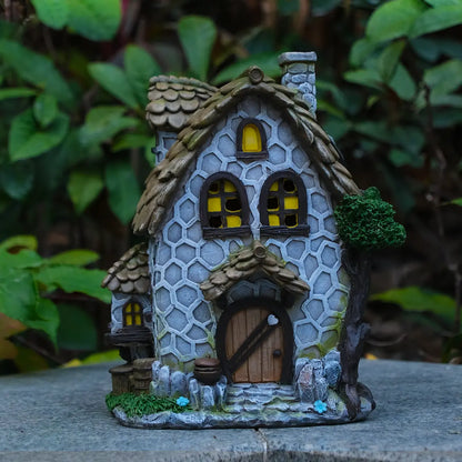 Hand-painted stone cottage fairy house on rock in garden