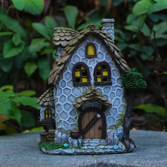 Hand-painted stone cottage fairy house on rock in garden