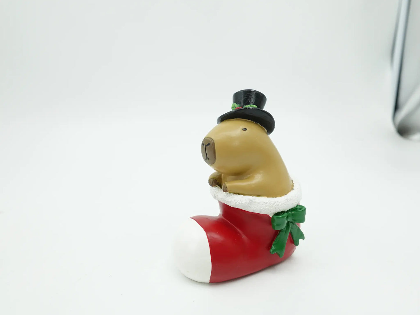 the hand-painted capybara gentleman seated inside the red Christmas boot