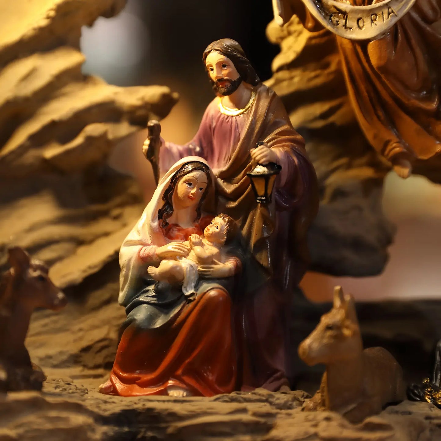 Close-up illuminated Holy Family figurine inside rustic nativity cave