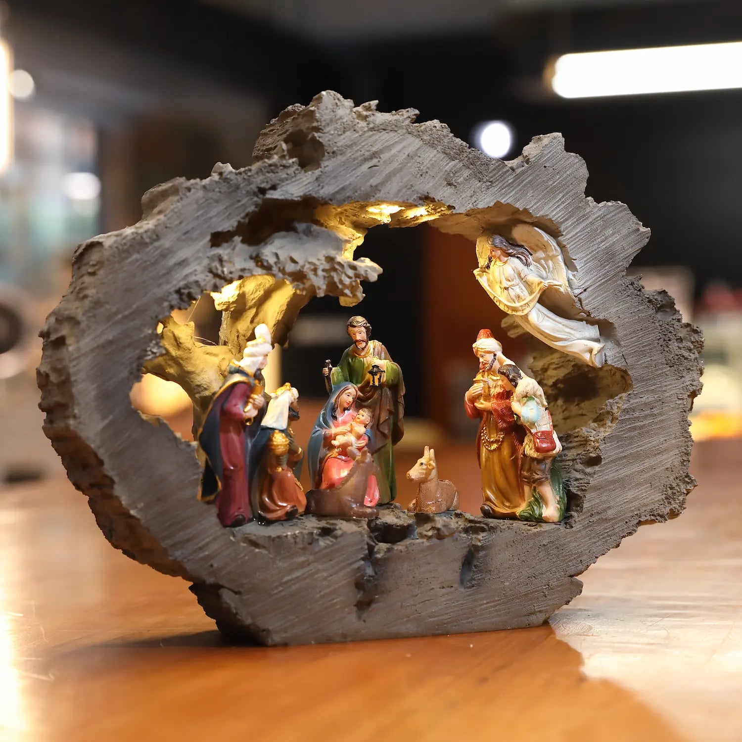 Front view of rustic bark stable nativity set with illuminated Holy Family figures