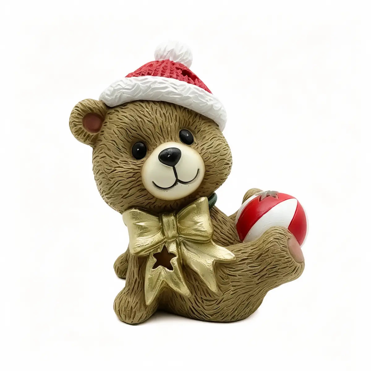 A brown teddy bear figurine wearing a red and white Santa hat, a gold bow tie, and holding a red and white ball, set against a plain white background.